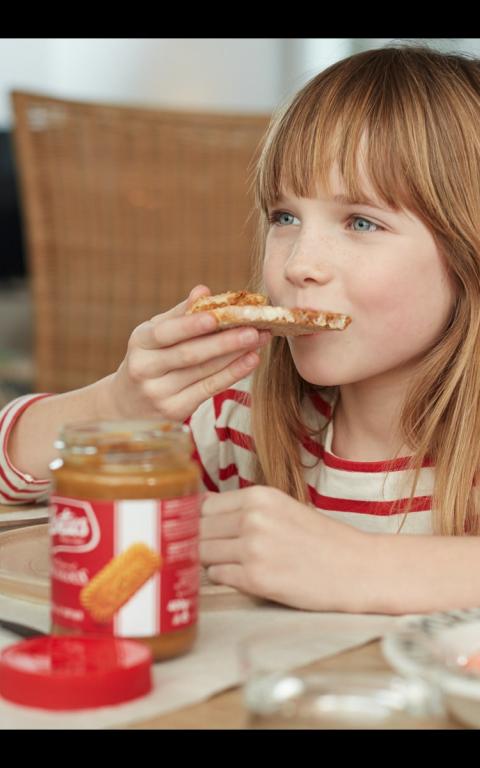 jeune fille degustant tartine avec L’original Lotus Biscoff à tartiner